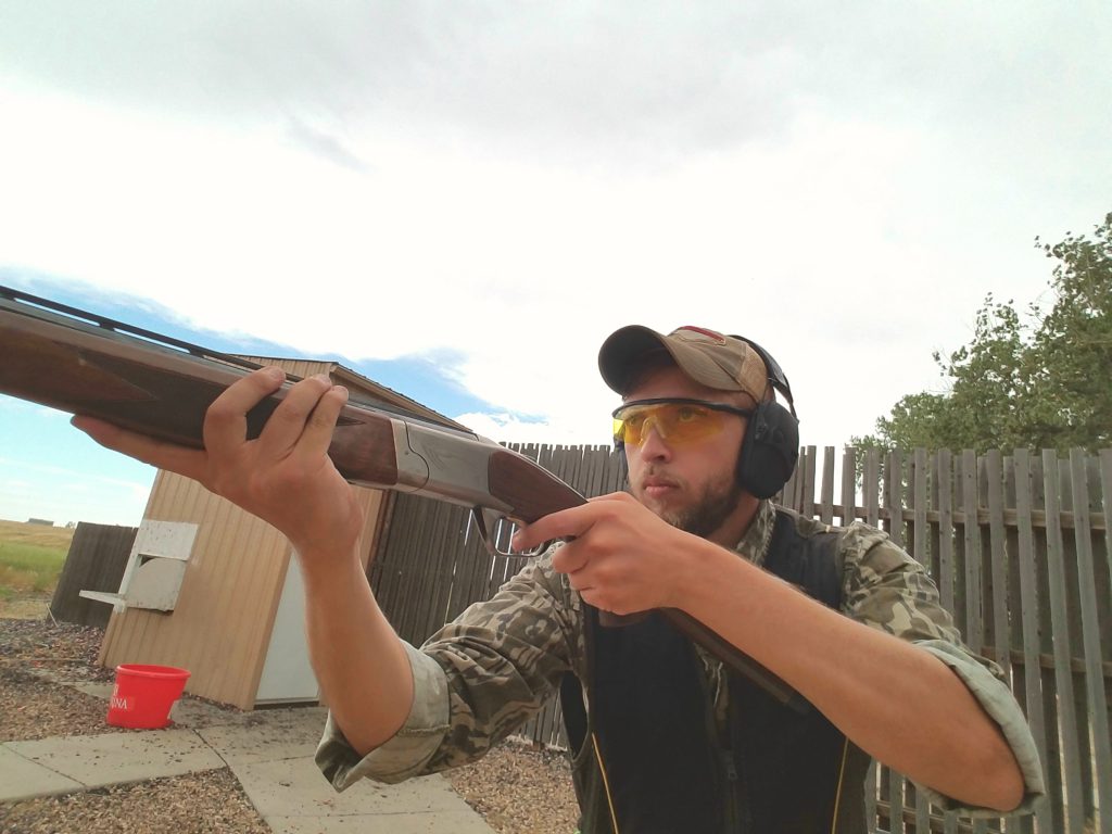 taking aim with a shotgun at the range