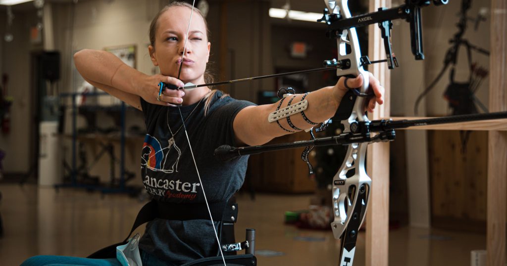 woman in wheelchair shoots compound bow