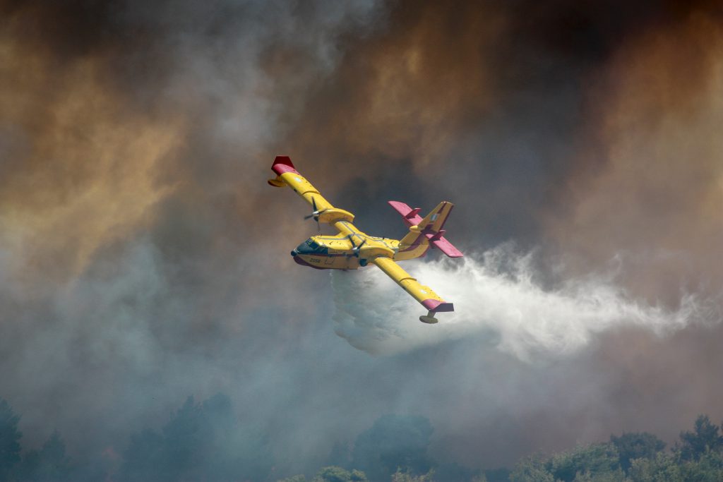 plane dropping water on wildfires