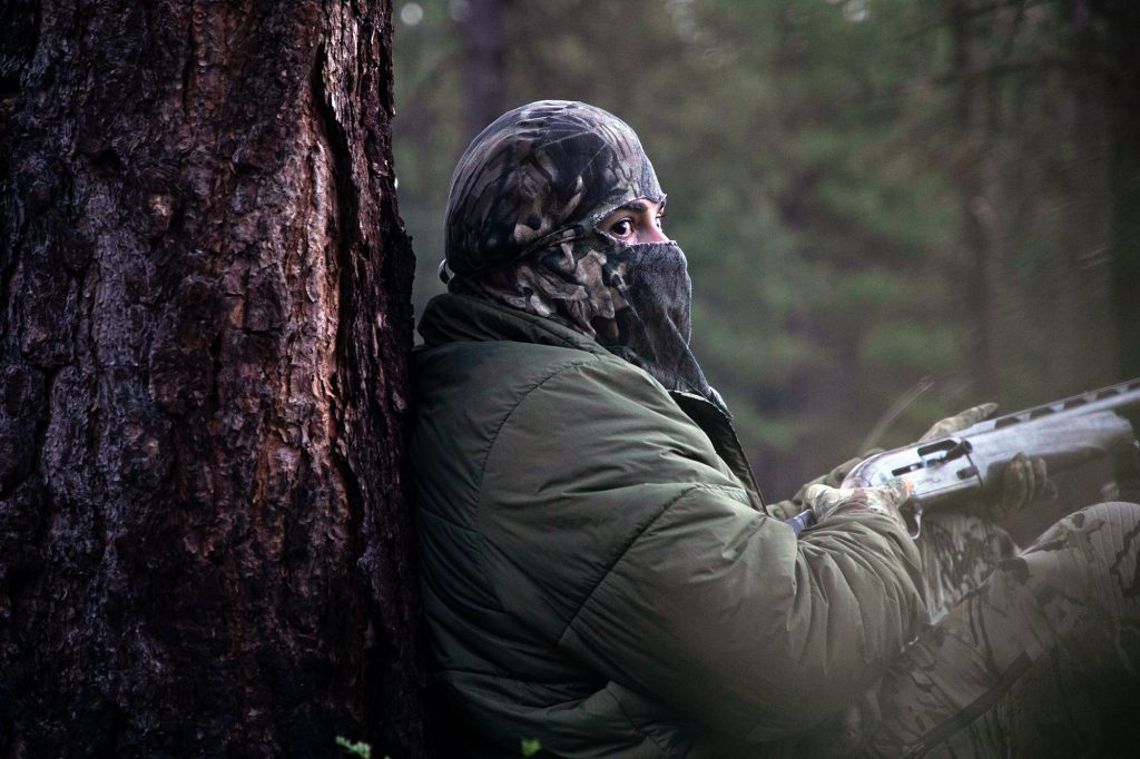 turkey hunter sitting against tree