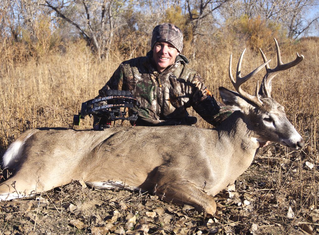 bowhunter with buck in colorado