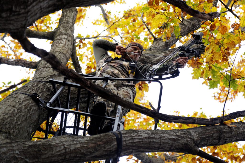 bowhunter at full draw in tree stand