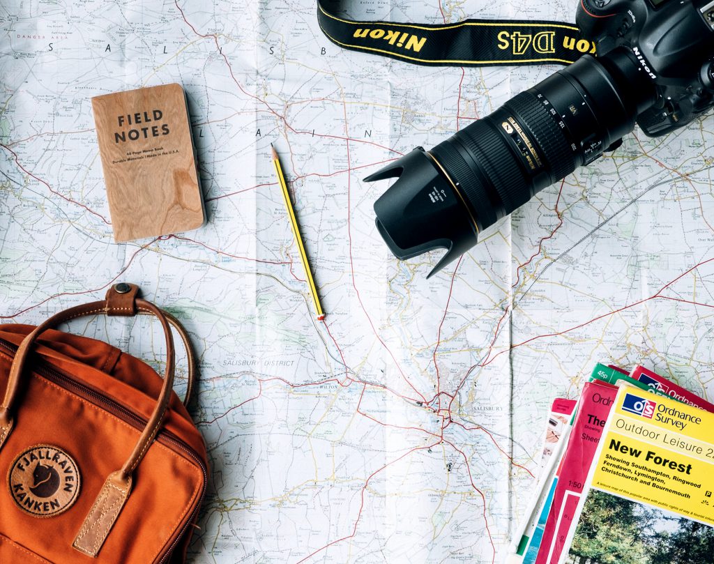 map with notebook and camera for planning an outdoor trip