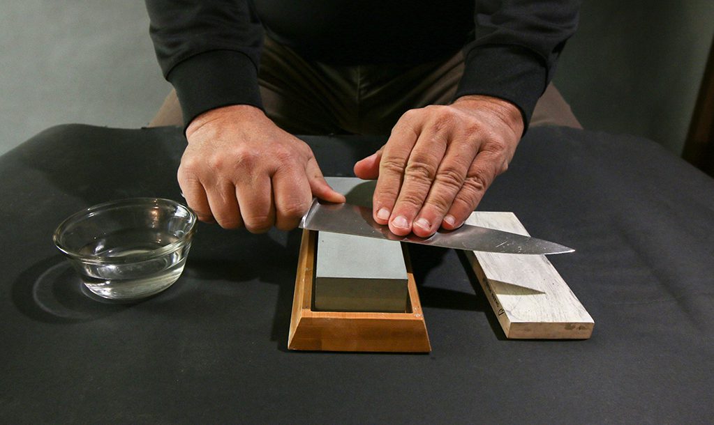 sharpening a knife on a whetstone