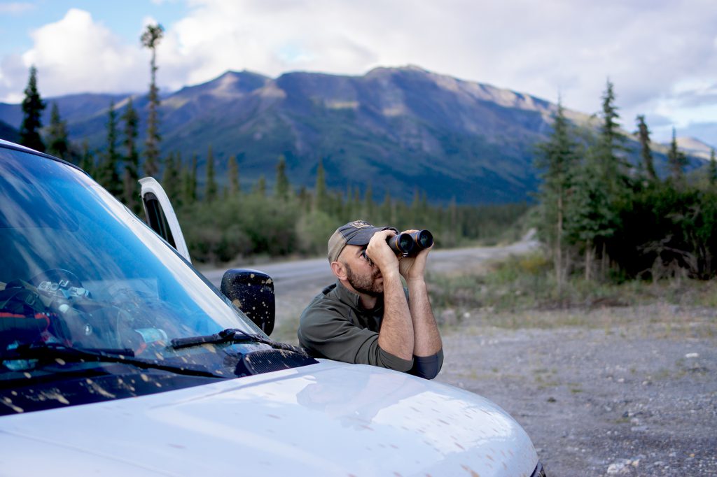 man glassing on van hood alaska caribou hunt