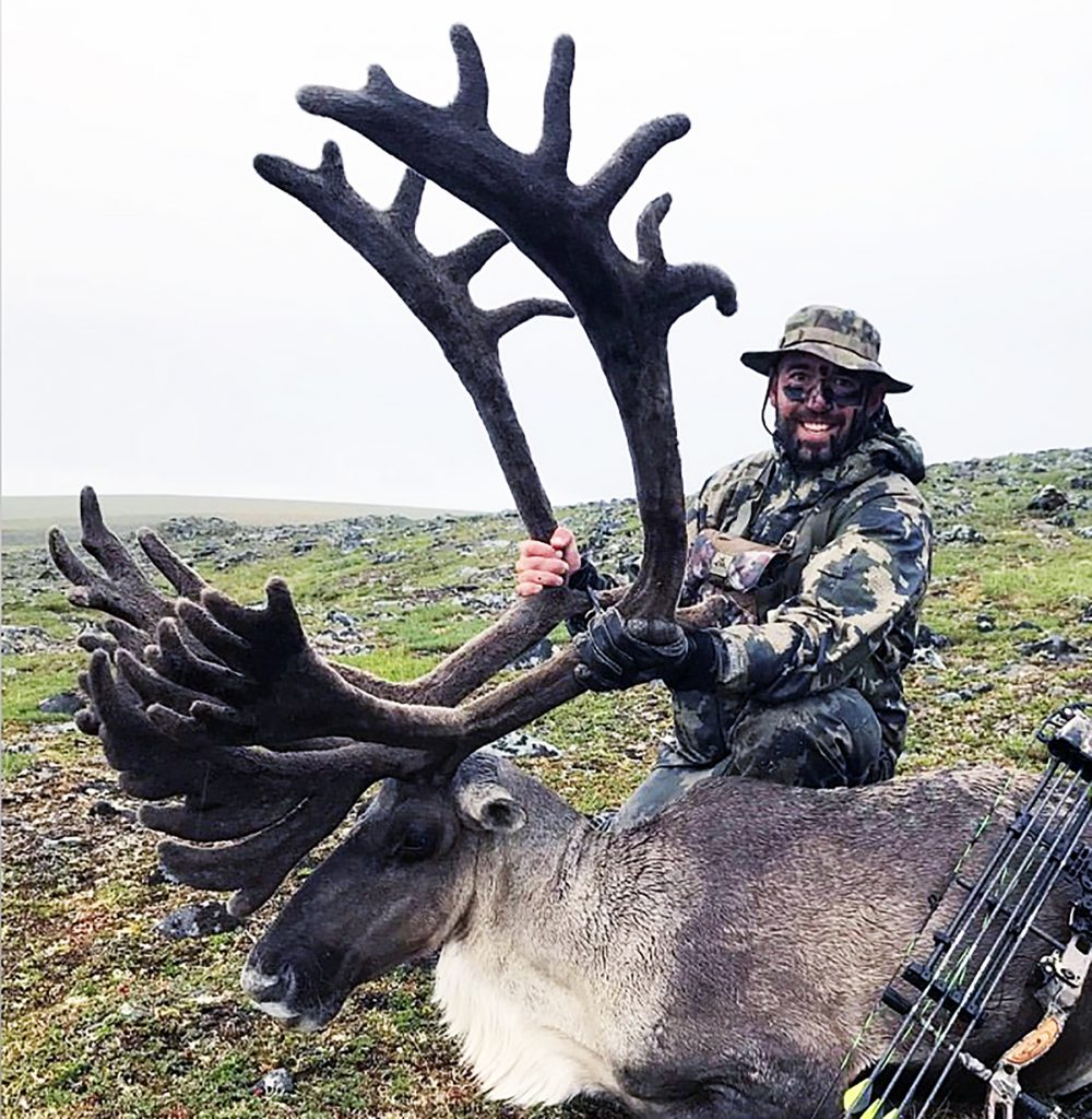 hunter with bull caribou and bow